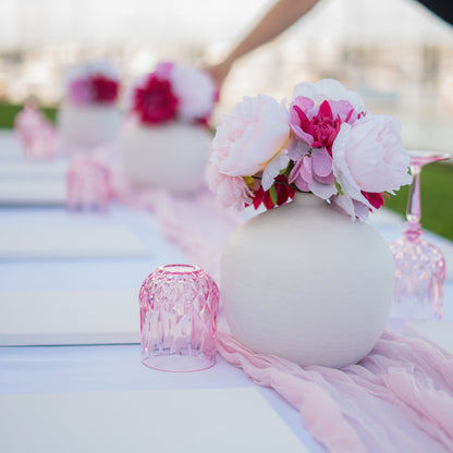 Decorative vase with pink flowers and ribbons table set up sip and paint experiences